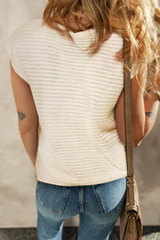 Tan knit top with open crochet floral appliqué detail and short sleeves.