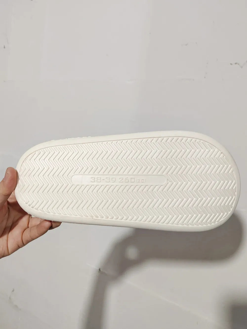White faux fur house slides sole with chevron tread pattern and size marking