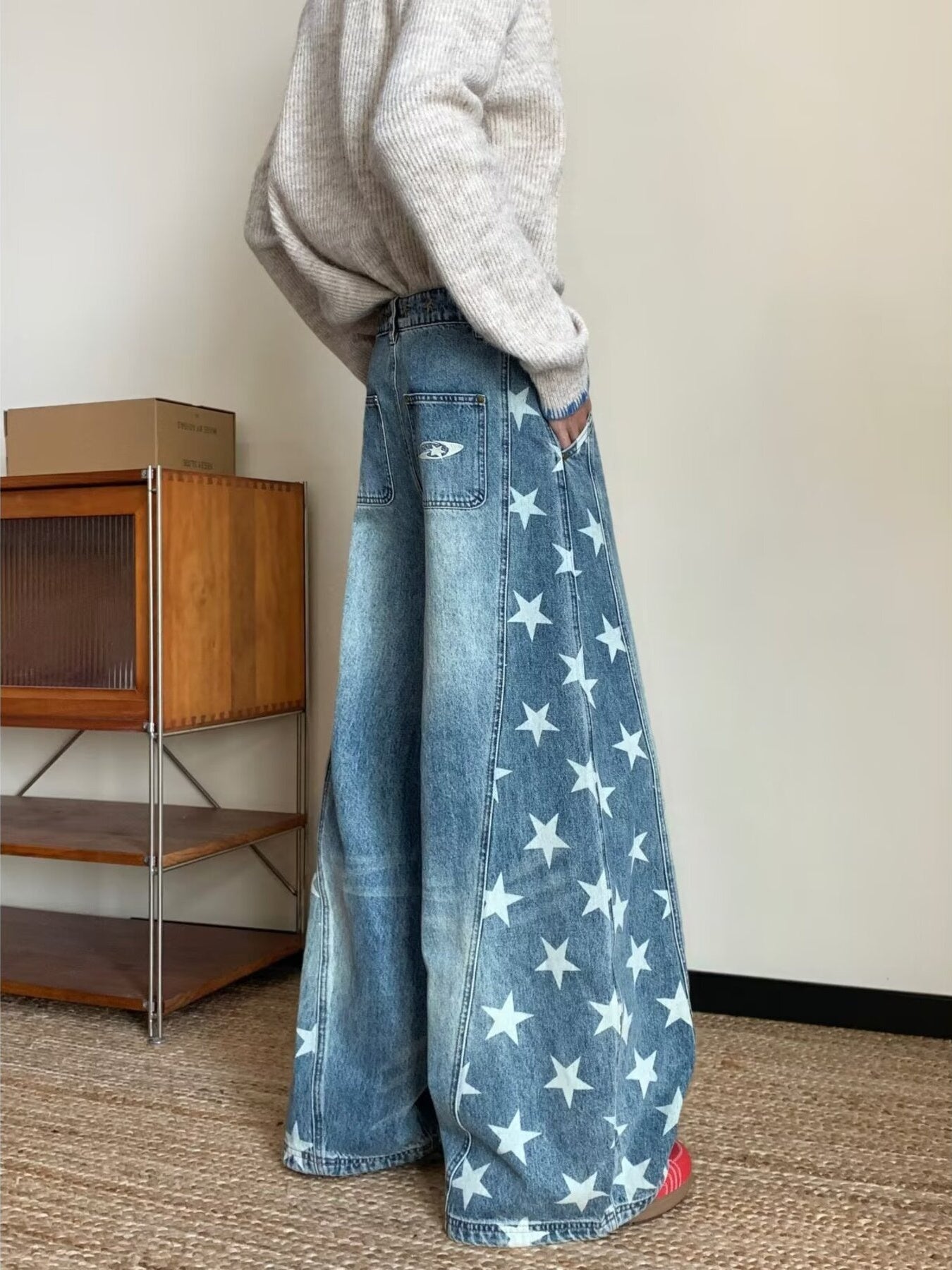 Men's blue wide leg jeans with all-over white star print and distressed details.