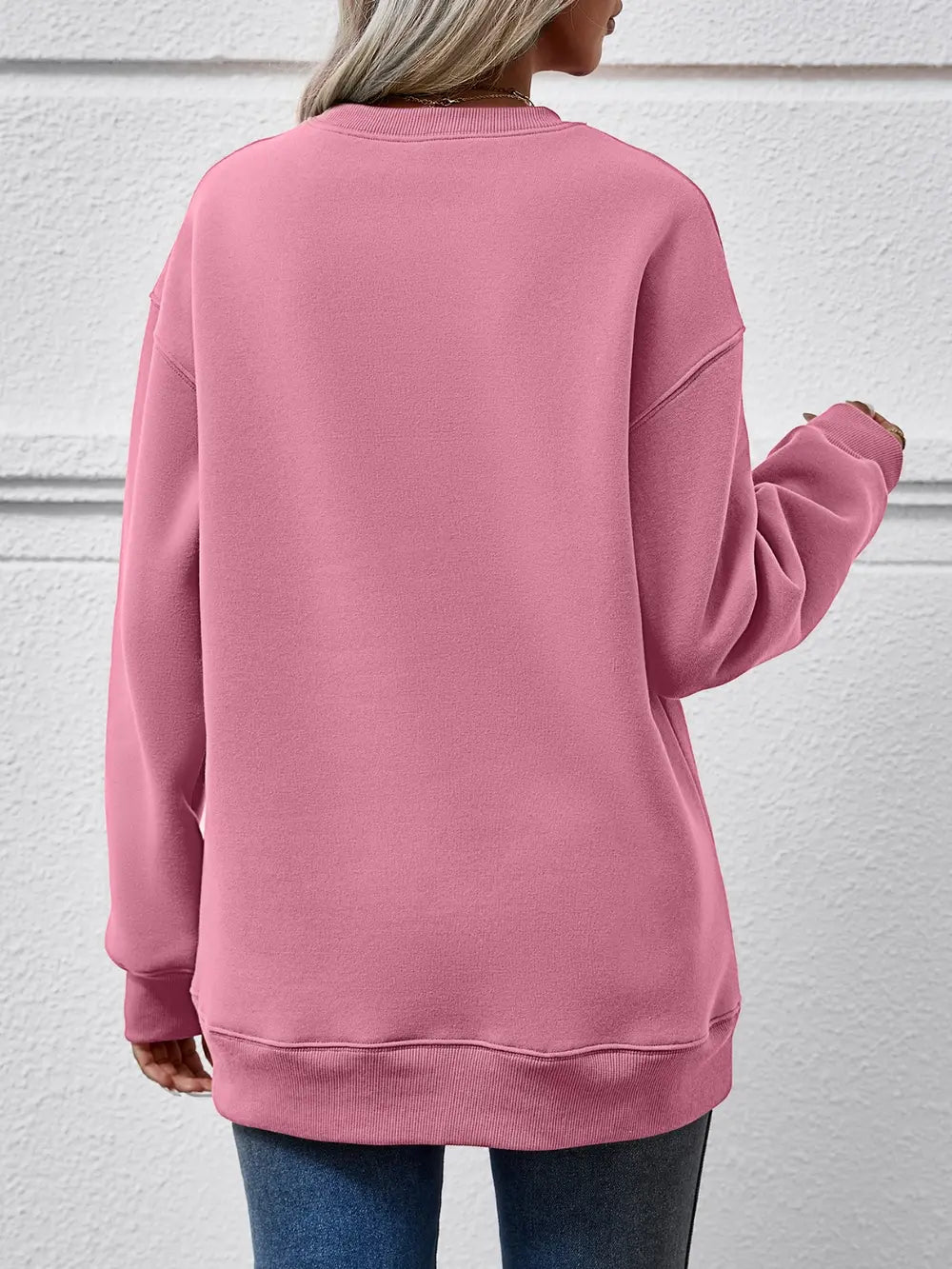 Blush pink crewneck sweatshirt with ribbed cuffs and hem, casual long sleeves.