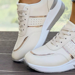Beige lace-up sneakers with metallic accents and a chunky sole.