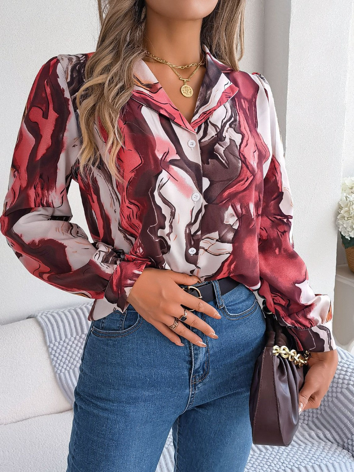 Women's abstract swirl print silk blouse in red and white with button front and collared neckline.