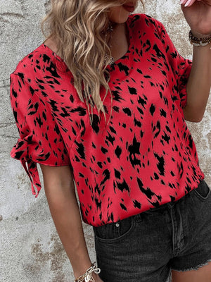 Scarlet Dalmatian print blouse with bow sleeves and a boatneck neckline.