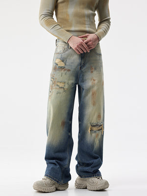 Men's distressed wide-leg jeans in blue denim with light wash and ripped details.