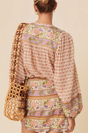 Bohemian print blouson sleeve top in floral with diamond and stripe patterns.