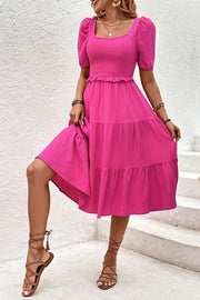 Hot pink tiered midi dress with smocked bodice, square neck, puff sleeves and ruffle hem.