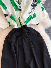 Abstract print white romper with green accents and black wide legs.