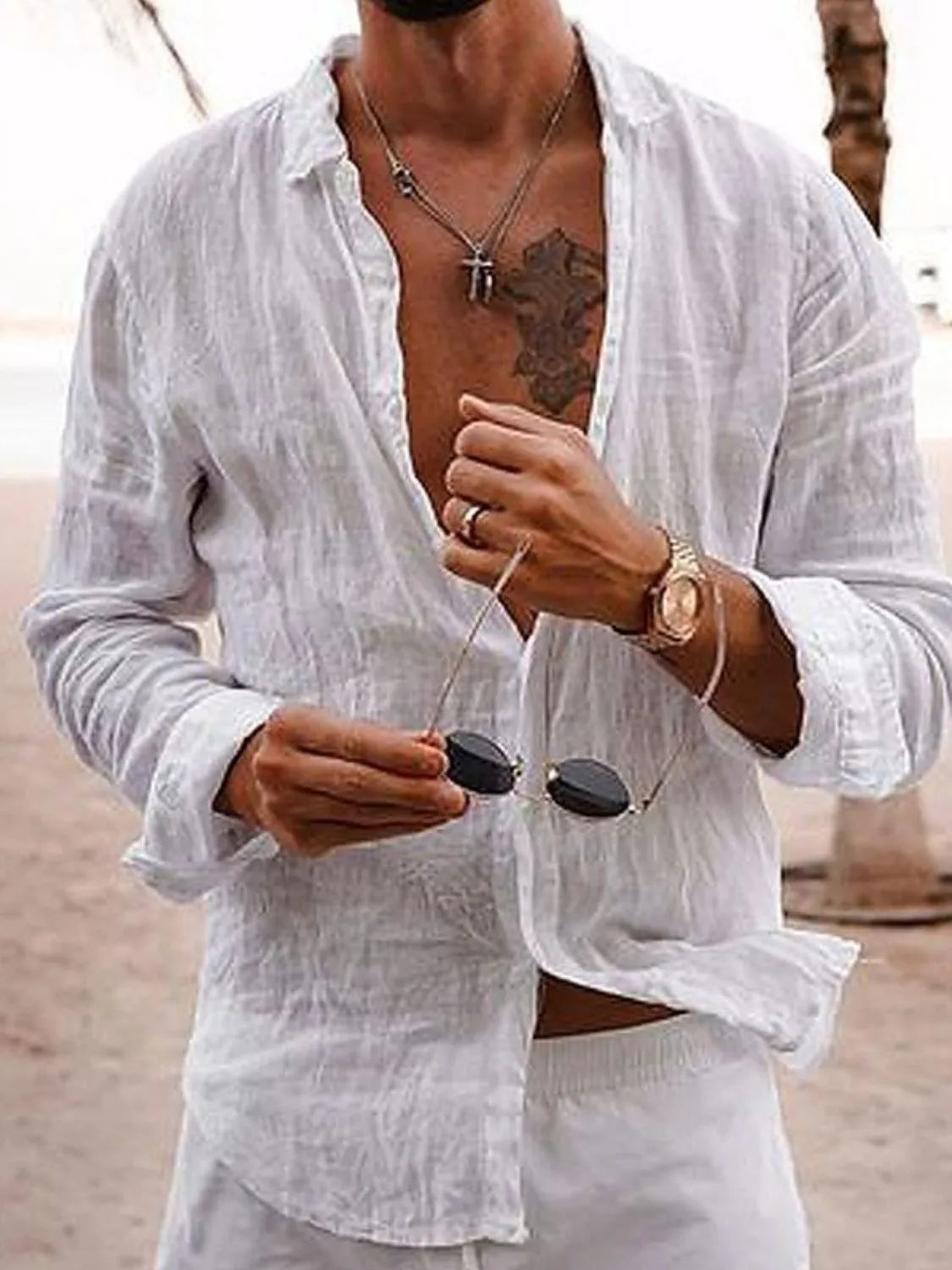 White linen button-front shirt with relaxed fit and long sleeves, styled casually.
