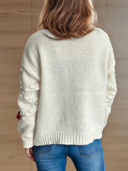 Cream knit cardigan with rose appliqué detail on sleeve, buttoned front, acrylic.