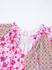 Boho floral print blouse in fuchsia pink with geometric print panels, ruffled neckline and tie detail.