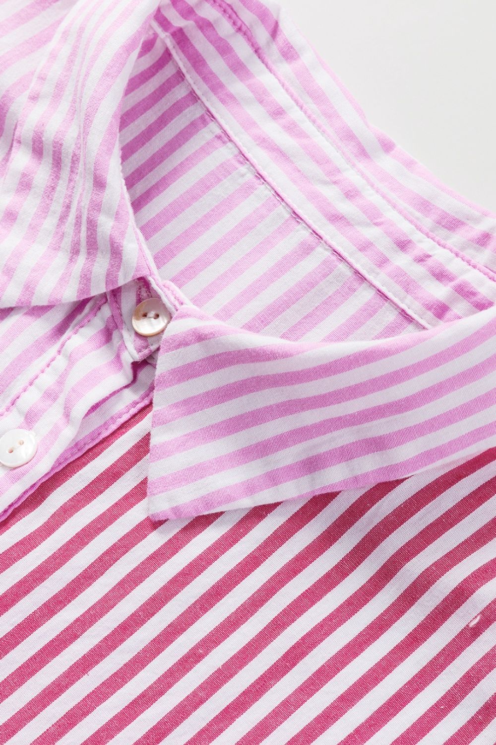 Pink striped button-up blouse with ruffle sleeves and collar detail