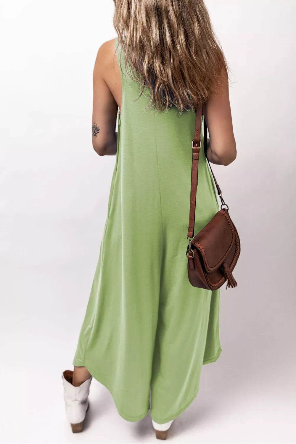Sleeveless wide-leg lime green casual romper with side pockets.
