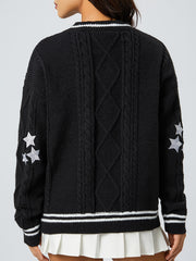Black cable knit cardigan with white stars on sleeve and striped trim.