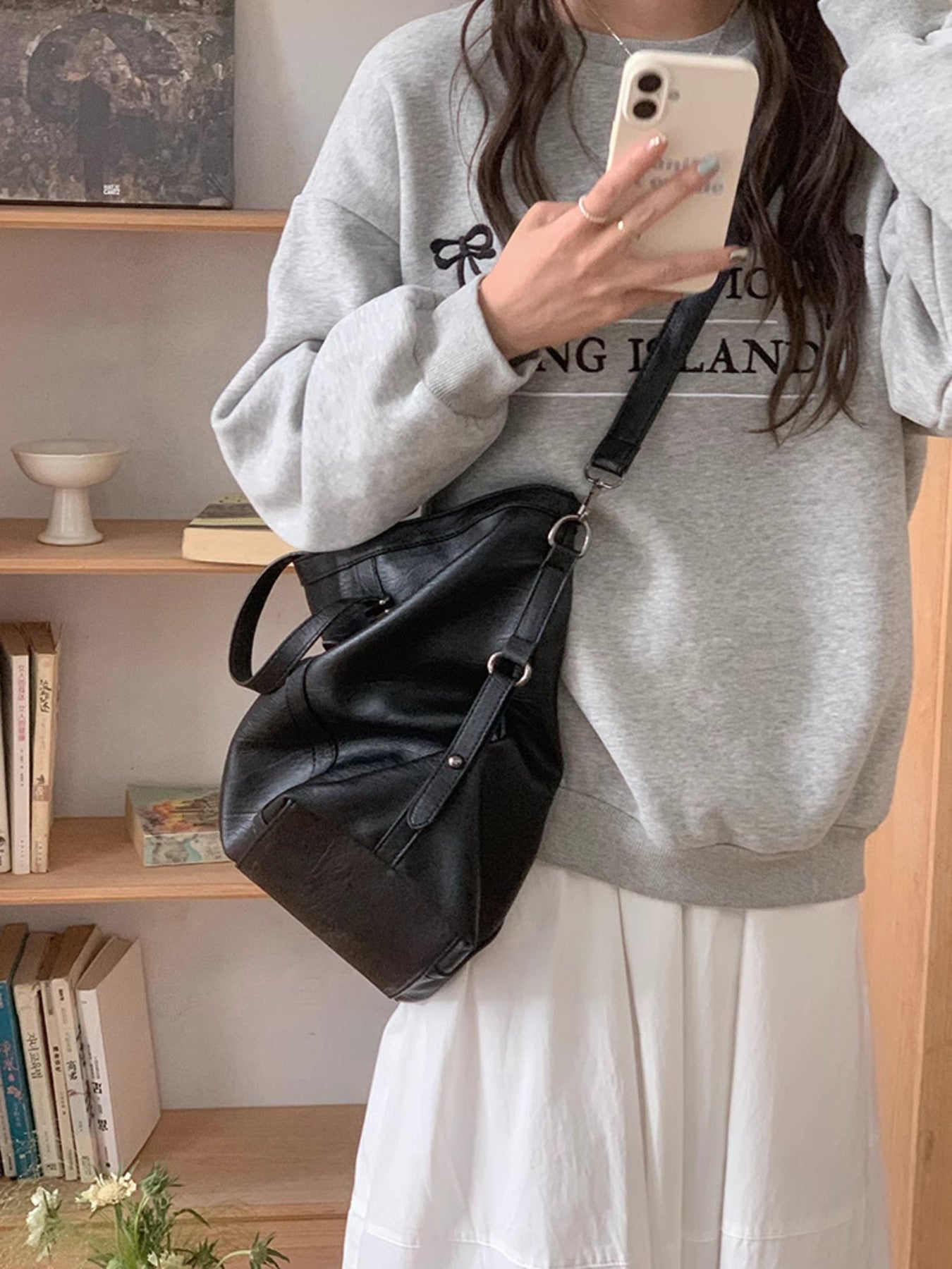 Black pu leather crossbody bag with adjustable strap and silver hardware.