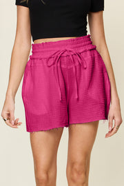 Textured gauze shorts in hot pink with drawstring waist and frayed hem