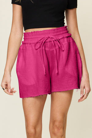 Textured gauze shorts in hot pink with drawstring waist and frayed hem