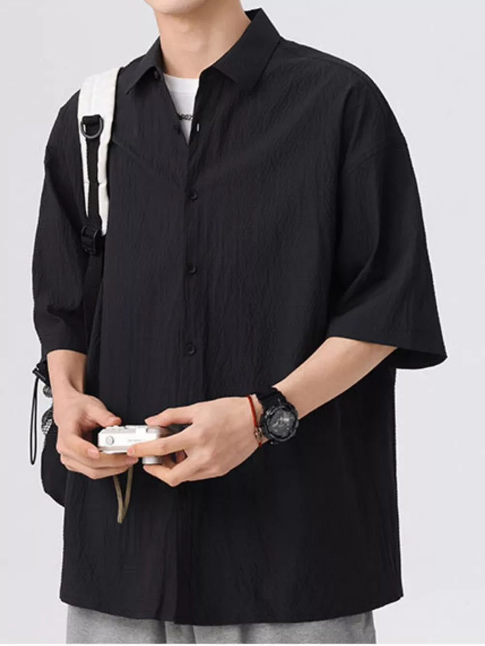 Black textured short-sleeve men's shirt with a button-down collar and relaxed fit.