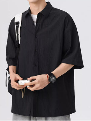 Black textured short-sleeve men's shirt with a button-down collar and relaxed fit.