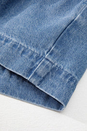Denim peplum blouse in medium blue with visible stitching detail.