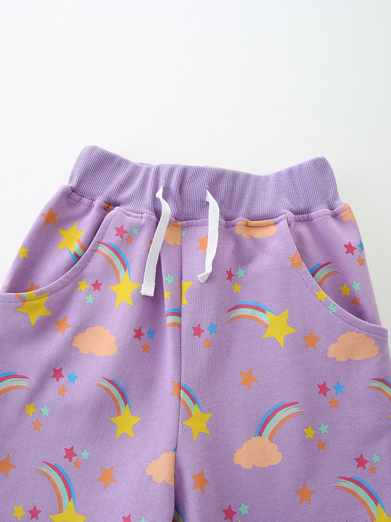 Lavender cotton toddler shorts with rainbow and star print, elastic waistband and drawstring.