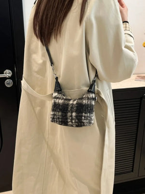 Shearling check mini shoulder bag with black trim and strap, worn casually.