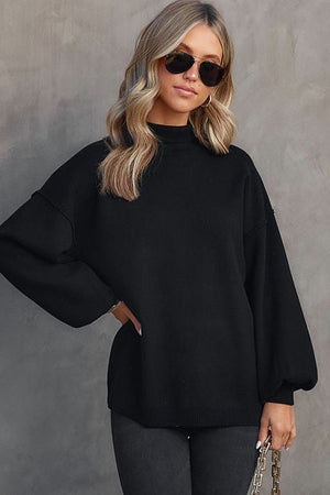 Black knit sweater with mock neck and voluminous balloon sleeves.