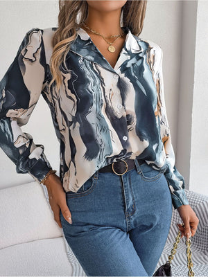 Women's abstract swirl print silk blouse with button front and collared neckline.