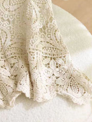 Lace overlay cropped vest in cream with intricate floral crochet detail and scalloped hem.