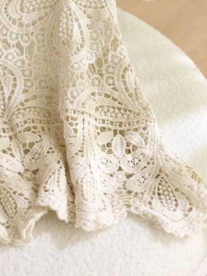 Lace overlay cropped vest in cream with intricate floral crochet detail and scalloped hem.