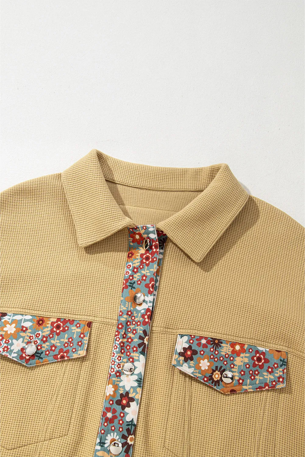Khaki waffle knit jacket with floral print panels on button placket and chest pockets.