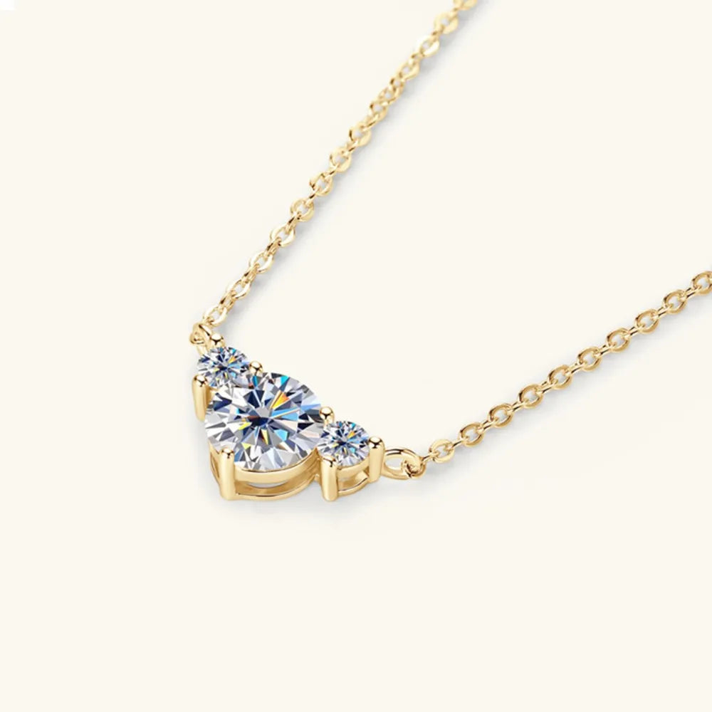 Gold diamond pendant necklace with three sparkling stones in a crescent shape.