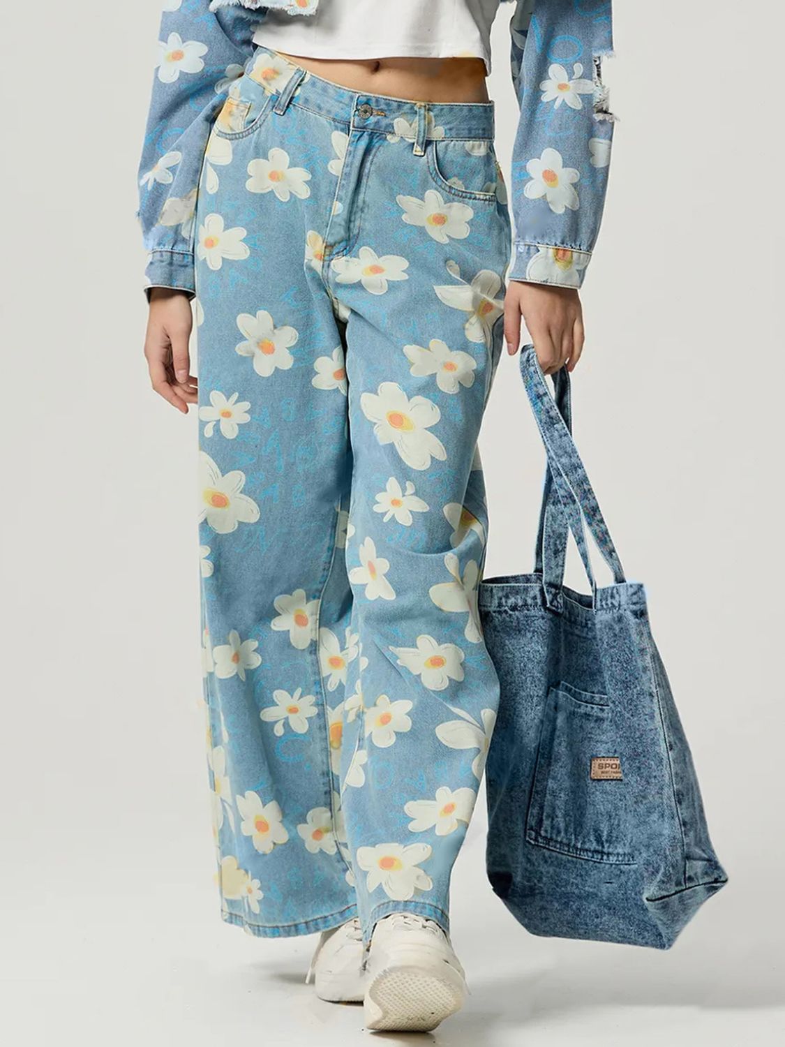 Light wash denim wide leg jeans with a white daisy floral print.