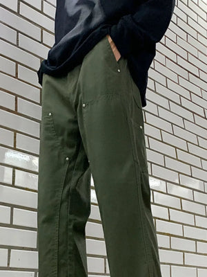 Men's army green relaxed fit cargo pants with silver button details and utility pockets.