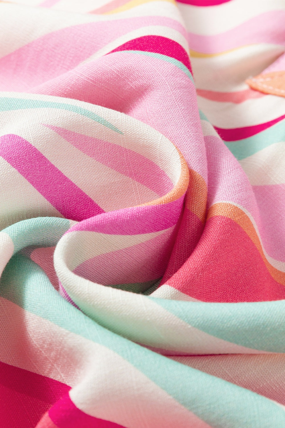 Blouse with prismatic stripes in pink, white, and aqua.