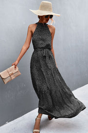 Black and white polka dot halter maxi dress with tiered skirt and tie waist.