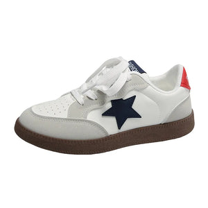 White retro court sneakers with navy star appliqué and red heel tab.