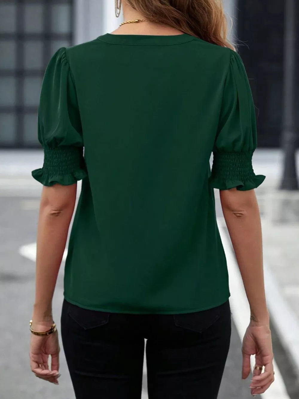 Sophisticated green blouse with puffed sleeves and smocked cuffs.