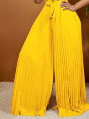 Yellow pleated wide leg romper with tied front detail.
