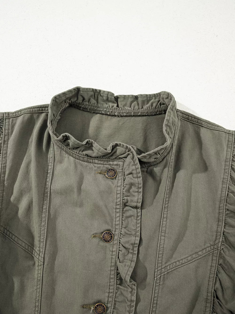 Ruffled denim vest in olive green with button closure and ruffled neckline detail.