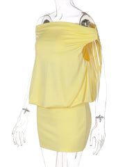 Yellow off-shoulder ruched mini dress with draped detail and sweetheart neckline.