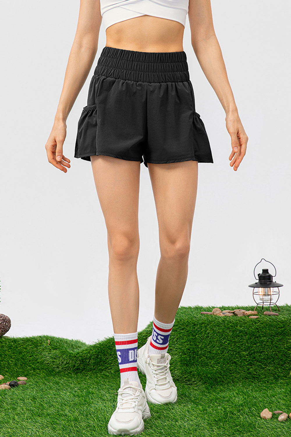 Black active shorts with gathered waistline and ruffled hem detail