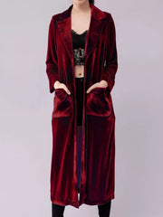 Burgundy velvet longline trench coat with pockets and draped open front.