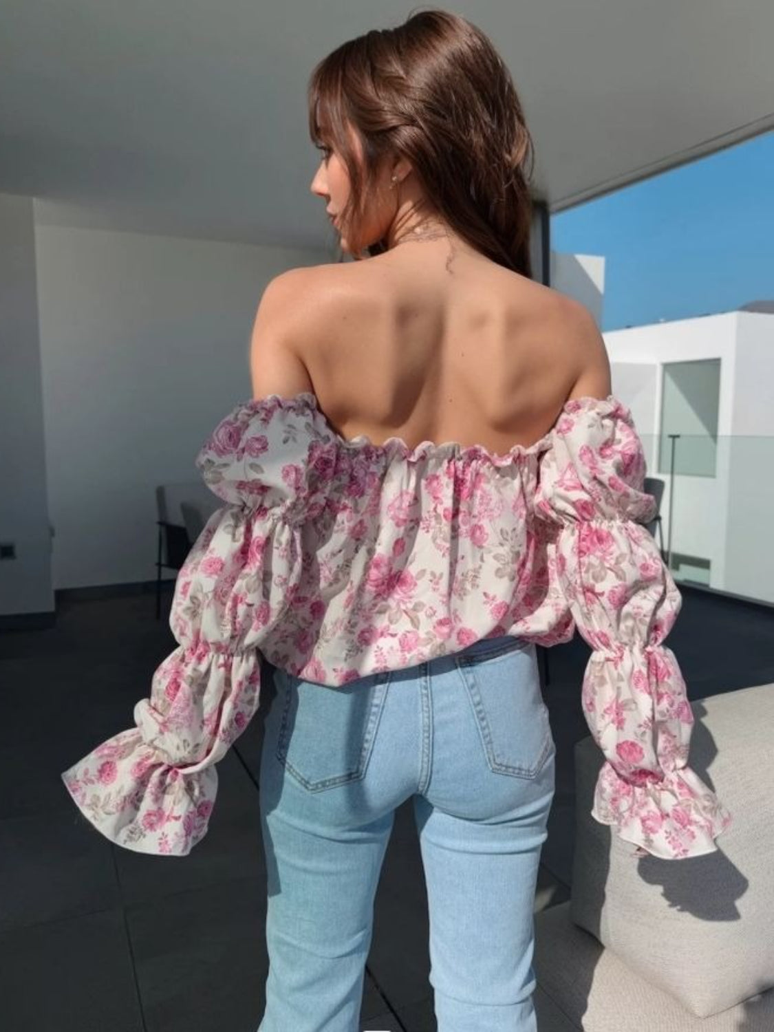 Romantic ruffle sleeve off-the-shoulder blouse in blush pink floral print with cinched cuffs.