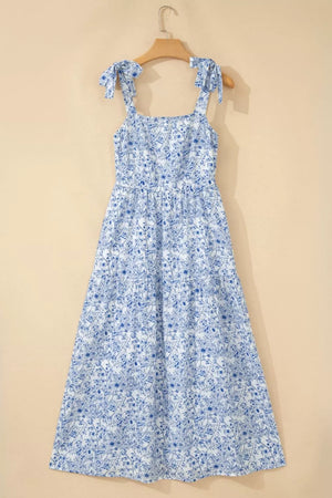 Maxi dress with blue floral print, square neck, tie straps, and tiered skirt.