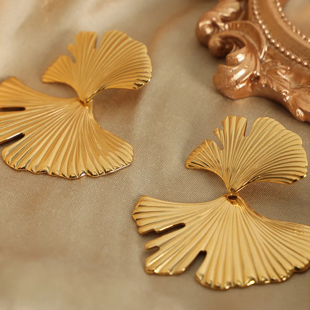 Gold Ginkgo leaf statement earrings with ribbed texture and elegant design.