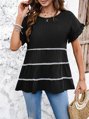 Black ribbed tiered blouse with ruffle sleeves and white pom-pom trim details.