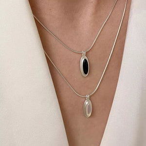 Geometric agate pendant necklaces in silver with black and white stones.