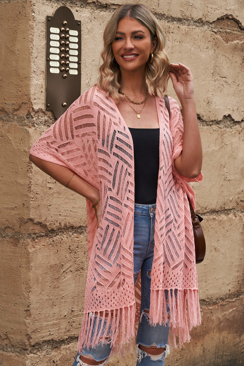 Blush pink open knit chevron fringe cardigan with short sleeves and boho styling.