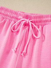 Pink cotton bikini bottoms with elastic waistband and drawstring detail.