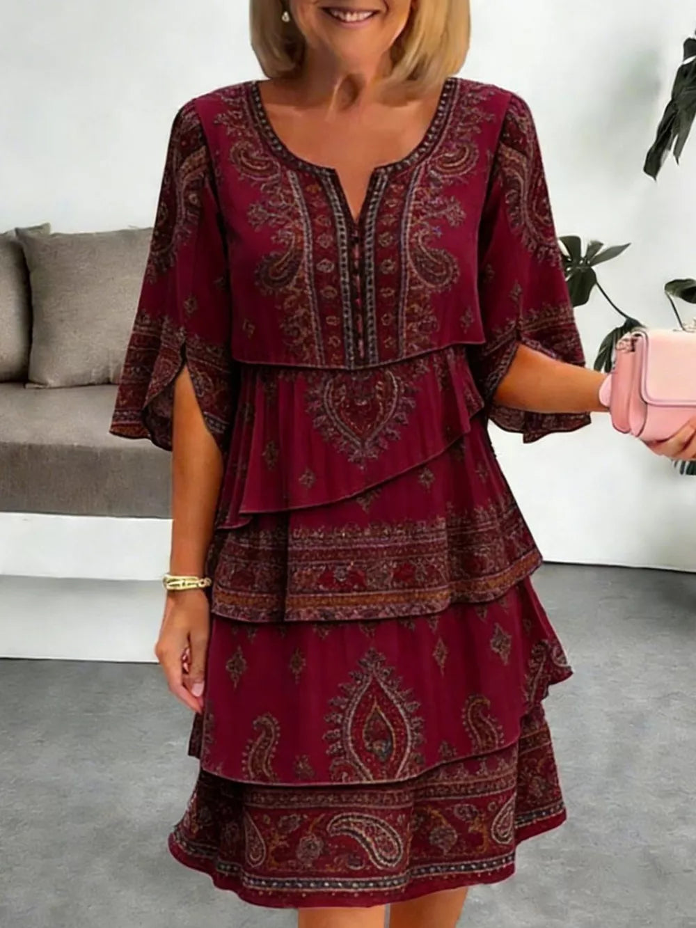 Burgundy paisley print tiered mini dress with split flutter sleeves and V-neck.